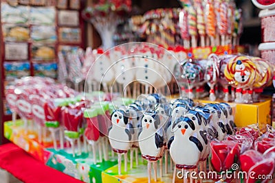 Christmas and New year`s street fair sweet food. Snowman shaped candies, lollypops and candy canes in shop Stock Photo