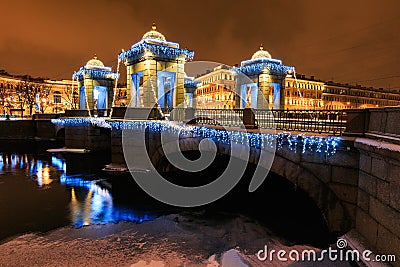 Christmas and New Year street decoration on bridge with pavilions with small domed caps, lights and river, St. Petersburg, Russia. Stock Photo