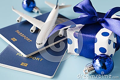 Christmas or New Year travel concept. Toy airplane with passports and gift box on blue background Stock Photo