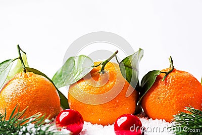 Christmas New Years greeting card poster banner with fresh tangerines on stem with green leaves fir tree branches balls in snow Stock Photo