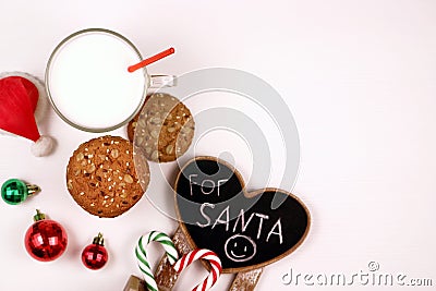 Christmas oatmeal cookies and glass of milk for Santa Claus on white background top view. Christmas greeting card with Stock Photo