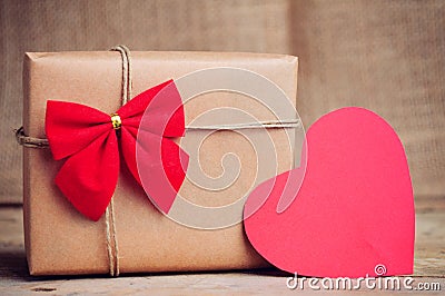 Christmas paper box with heart decoration on wooden surface Stock Photo