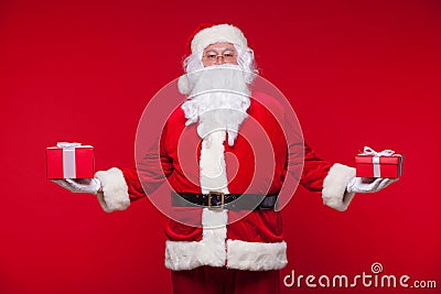 Christmas. Photo Santa Claus giving xmas present and looking at camera, on a red background Stock Photo