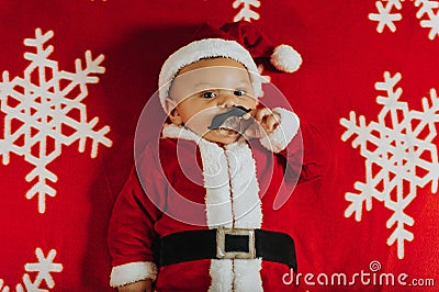 Christmas portrait of adorable newborn baby wearing Santa Claus` outfit Stock Photo