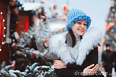 Christmas portrait of happy young woman walking in winter snowy city Stock Photo