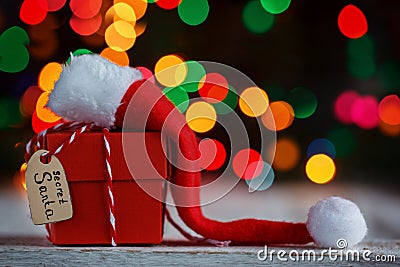 Christmas present or box for secret santa with Santa hat. Greeting card. Stock Photo