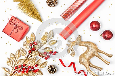 Christmas presents preparation - gift box, mistletoe, fircones,reindeer, christmas balls and paper in golden and red colors over Stock Photo