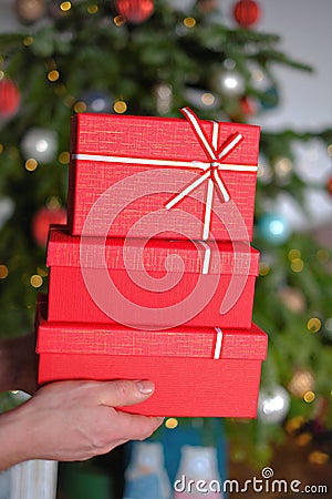 Christmas presents. Red gift boxes on Christmas tree background. gifts for the winter holidays. Christmas and New Years Stock Photo