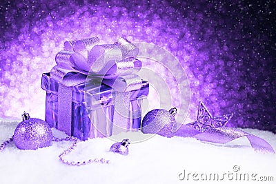 Christmas purple gift box with balls and star on snow Stock Photo
