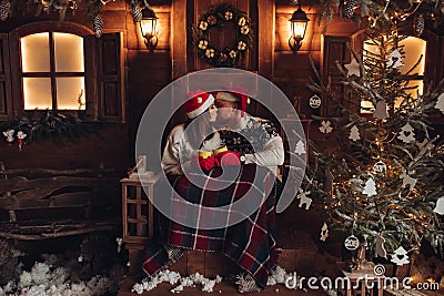 Christmas romance in Santa Claus hats beautiful house New Year`s atmosphere Stock Photo