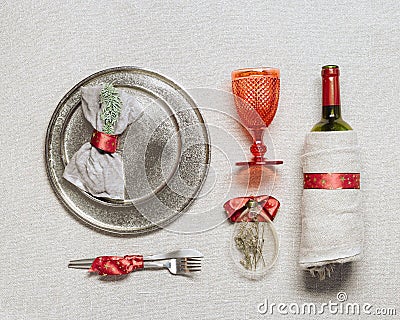 Christmas rustic table setting, bright tableware, red wine glass, plate, knife, fork, wine bottle, glass Christmas Stock Photo
