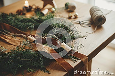 Christmas rustic wreath. Stylish christmas wreath with cedar branches, ribbon, vintage bells, pine cones, scissors on wooden table Stock Photo