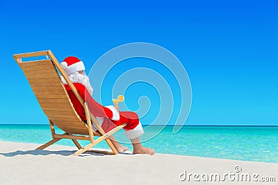 Christmas Santa Claus with fresh juice on sunlounger at tropical Stock Photo