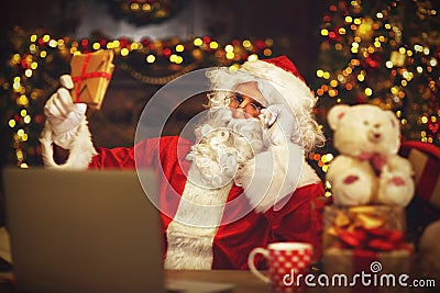 Christmas. Santa Claus with laptop reading letter Stock Photo