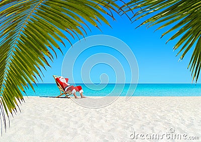 Christmas Santa Claus relaxing on sunlounger at ocean sandy tropical beach Stock Photo