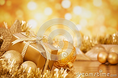 Christmas scene with gold baubles and gift, gold background Stock Photo