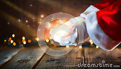 Christmas scene. Santa Claus showing glowing stars and magic dust in open hands Stock Photo