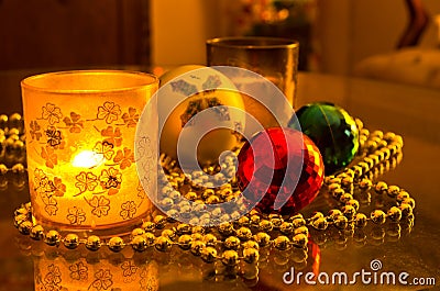 Christmas shiny colored decorations and candle in a glass Stock Photo