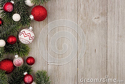 Christmas side border of red and white baubles with branches on gray wood Stock Photo