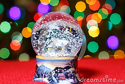 Christmas Snow Globe in front of Christmas tree lights closeup Stock Photo