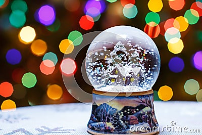 Christmas Snow Globe in front of Christmas tree lights closeup Stock Photo