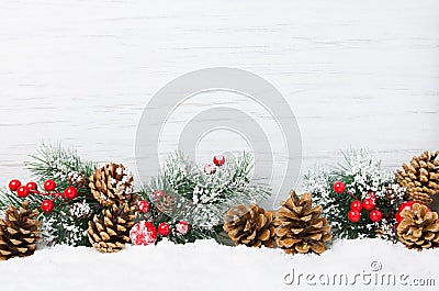 Christmas snow scene. Christmas tree branches with cones and ornaments on wooden light background, Stock Photo