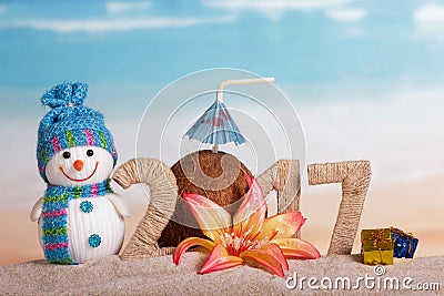 Christmas snowman, coconut and inscription 2017 in the sand, decorated with flower, gifts Stock Photo