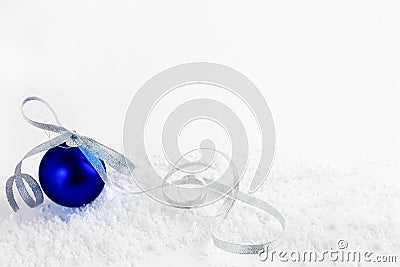 Christmas snowy background with blue ornament with silver ribbon Stock Photo