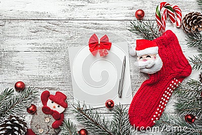 Christmas sock with presents. Christmas decoration stocking and toys hanging over gray rustic wooden background. Stock Photo