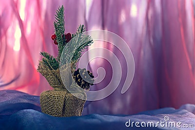 Christmas spruce twig with a cone in a burlap bag and dark red berries. Stock Photo