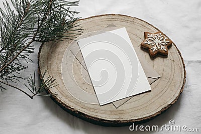 Christmas stationery. Blank greeting card, invitation mockup on cut wooden round board with star gingerbread cookie Stock Photo