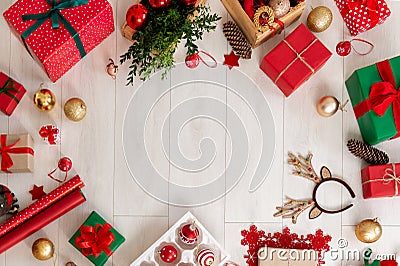 Christmas still life border. Presents, decorations, wrapping paper and ornaments on wooden floor. Top view. Stock Photo