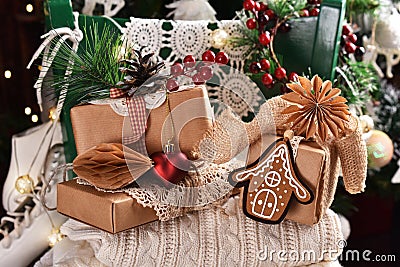 Christmas still life with wool sweaters and paper wrapped presents on green chair Stock Photo