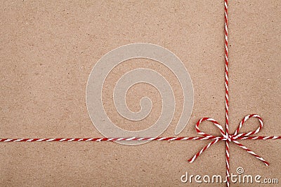 Christmas string or twine tied in a bow on kraft paper backdrop Stock Photo