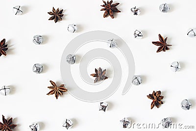 Christmas styled stock composition. Glittering silver jingle bells and anise stars on white background. Flat lay, top Stock Photo