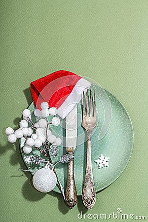 Christmas table setting with ceramic plates, traditional decor on Savannah Green color background Stock Photo