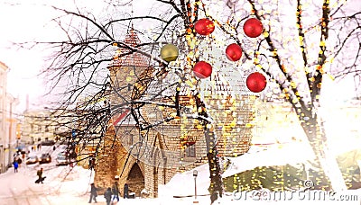 Christmas Tallinn tree decoration red ball and illumination medieval towers and snowy street people walking holiday in Estonia Stock Photo
