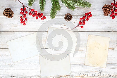 Christmas theme background with blank photo paper and decorating elements on white wood table. Stock Photo