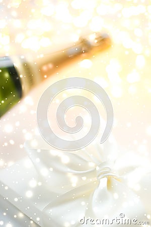 New Years Eve holiday champagne bottle and a gift box and shiny snow on marble background Stock Photo