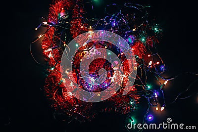 Christmas tiny lights playing in all colors on a black background. Abstract art. Christmas bulbs. The light bulbs on the wire Stock Photo