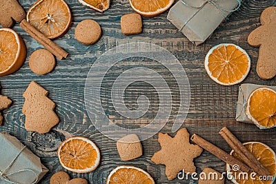 Christmas top view over a brown wooden background with gift boxes packed in a craft paper with dryed oranges, cookies Stock Photo