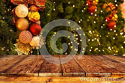 Christmas tree background with decoration and blurred light bokeh with empty dark wooden deck table for product montage. Stock Photo