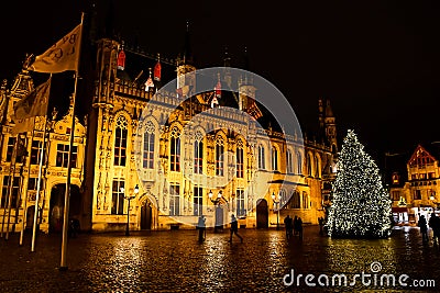 A Christmas tree and colourful lights in Brugge` city centre. A night landscape of Brugge, Belgium. Editorial Stock Photo