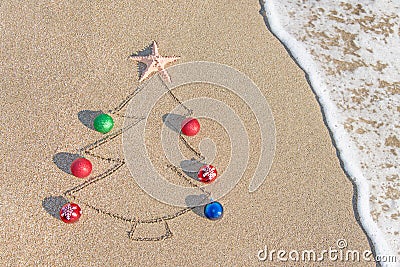 Christmas tree contour with decorations, star and wave on the beach Stock Photo