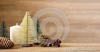 Christmas tree decoration background on wood table with snow.pine cone,mistletoe and bell ball hanging with blur wood wall Stock Photo