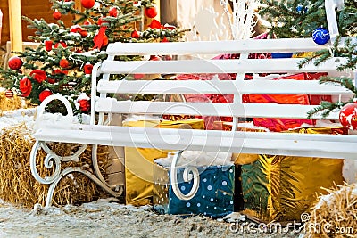 Christmas tree decorations, gifts, bench, hay outdoors Stock Photo