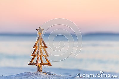 Christmas tree with fairy lights on the beach in summer Stock Photo