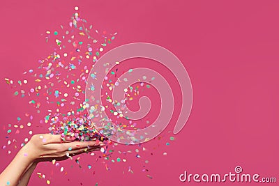 Christmas tree from falling confetti on woman hands against bright pink banner background Stock Photo