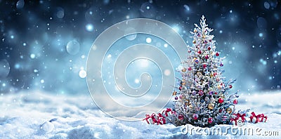 Christmas Tree With Gift On Snow At Night Stock Photo