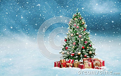 Christmas tree with golden and red presents in a snowy winter landscape Stock Photo